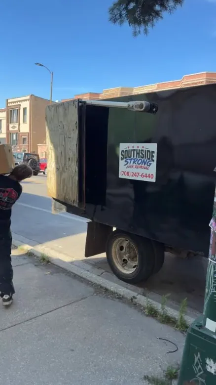 Southside Strong's black dump trailer parked at the curb on a city street